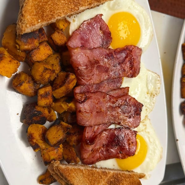 Route 12 Cafe's breakfast plate with crispy bacon, fried eggs, roasted sweet potatoes, and toast.